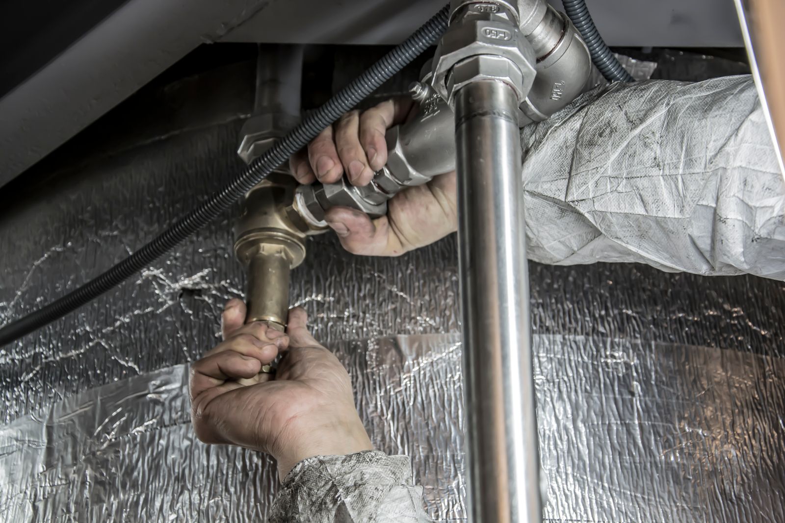 Licensed plumber replacing old polybutylene supply pipe with new piping in a Wilmington NC home