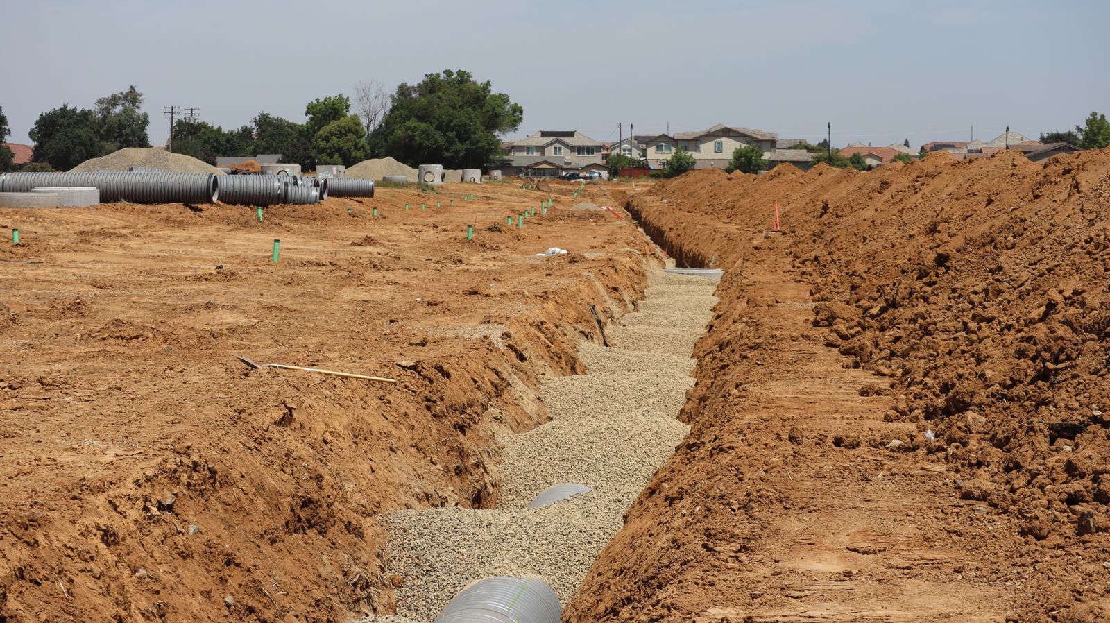 Suburban sewer line work site showing minimal excavation access pits used for trenchless sewer repair in Wilmington NC