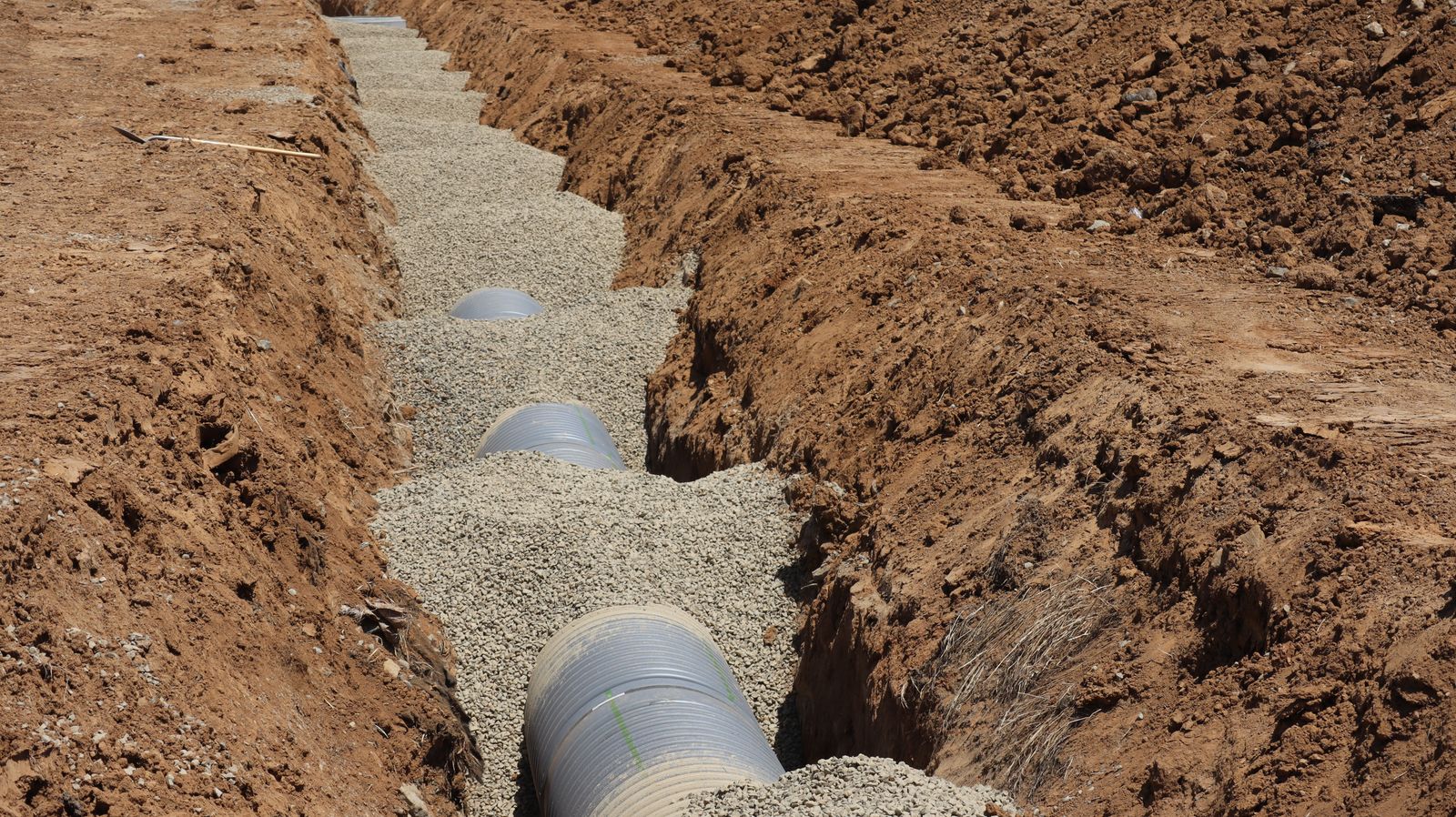 New sewer pipe being installed in an open trench during a residential sewer line replacement in Wilmington NC
